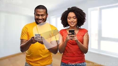 Image of happy african american couple with smartphones