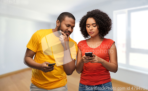 Image of happy african american couple with smartphones