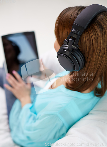 Image of woman with tablet pc and headphones at home