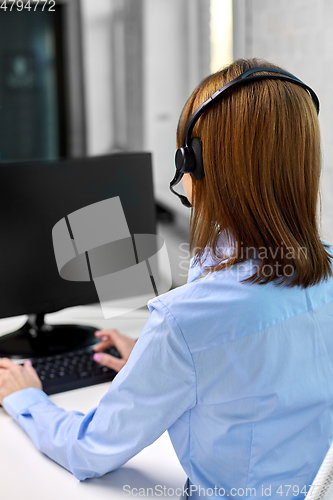 Image of businesswoman with headset and computer at office