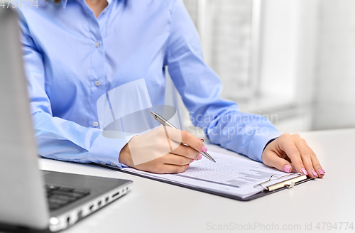 Image of businesswoman with papers working at office