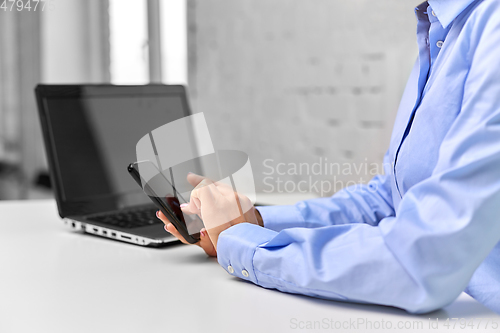 Image of businesswoman with smartphone at office