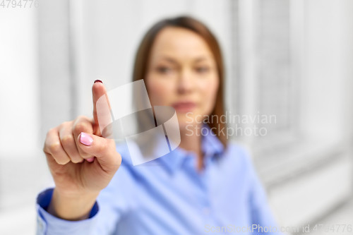 Image of businesswoman touching something with finger