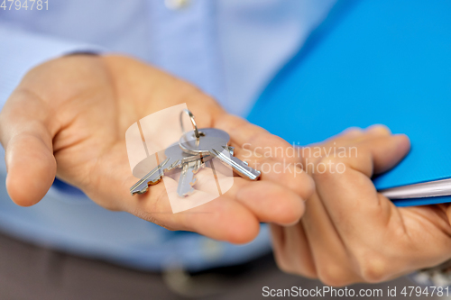 Image of close up of male hands holding keys and folder