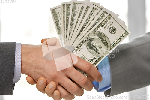 Image of close up of businessmen's hands holding money