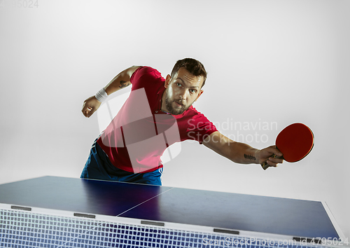 Image of Young man playing table tennis on white studio background