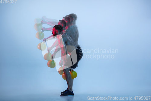 Image of Young caucasian bodybuilder training over blue background