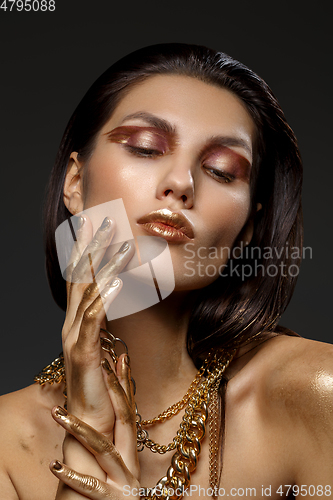 Image of beautiful girl with many golden and bronze chains