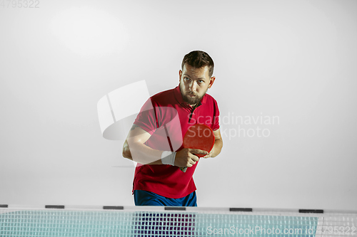 Image of Young man playing table tennis on white studio background