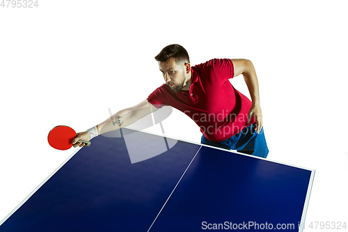 Image of Young man playing table tennis on white studio background