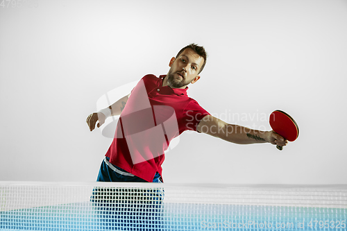 Image of Young man playing table tennis on white studio background