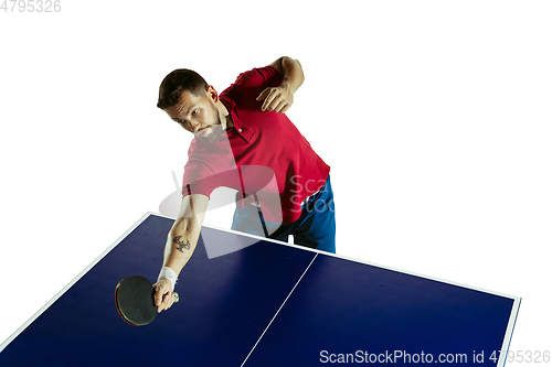 Image of Young man playing table tennis on white studio background