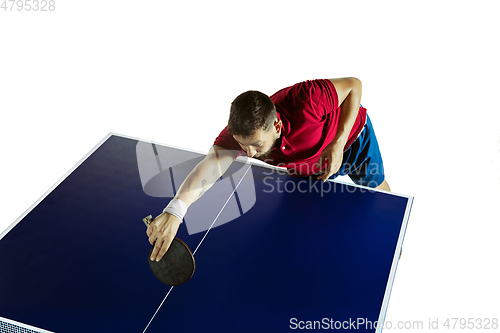 Image of Young man playing table tennis on white studio background