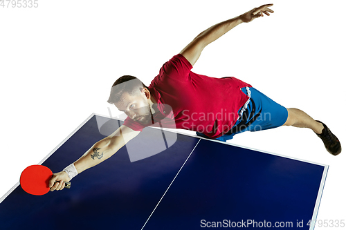 Image of Young man playing table tennis on white studio background