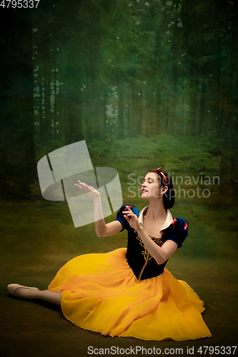 Image of Young ballet dancer as a Snow White with poisoned apple in forest
