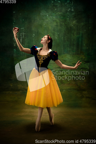 Image of Young ballet dancer as a Snow White with poisoned apple in forest