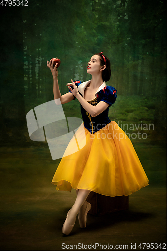 Image of Young ballet dancer as a Snow White with poisoned apple in forest