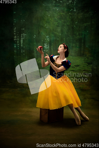 Image of Young ballet dancer as a Snow White with poisoned apple in forest