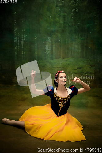 Image of Young ballet dancer as a Snow White with poisoned apple in forest