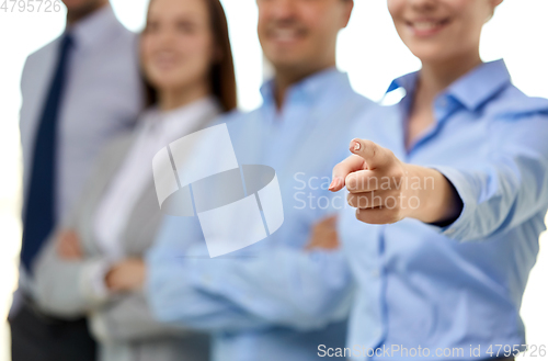 Image of close up of smiling businesswoman pointing finger