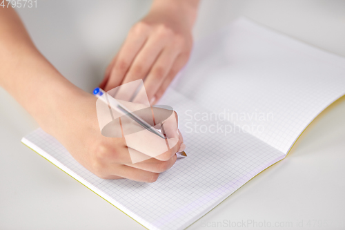 Image of hands of student girl with pen writing to notebook