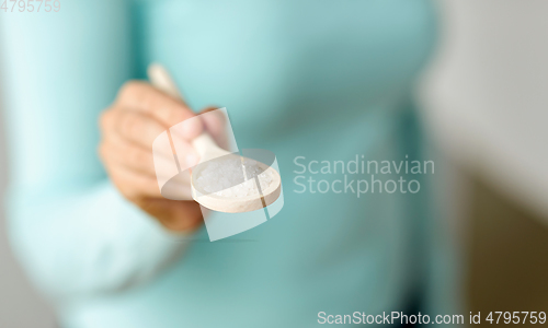 Image of close up of woman with sea salt on wooden spoon