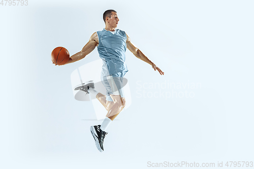 Image of Young caucasian basketball player against white studio background