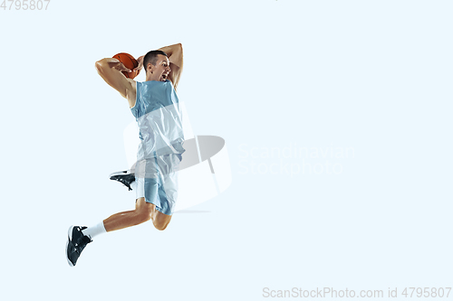 Image of Young caucasian basketball player against white studio background