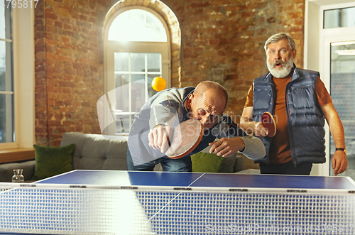 Image of Senior men playing table tennis in workplace, having fun