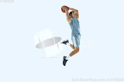 Image of Young caucasian basketball player against white studio background