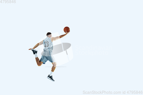 Image of Young caucasian basketball player against white studio background