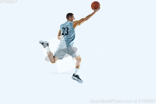 Image of Young caucasian basketball player against white studio background