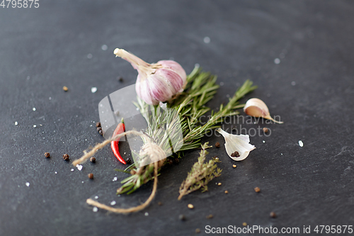 Image of rosemary, garlic and chili pepper on stone surface