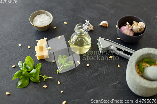 Image of ingredients for basil pesto sauce on stone table