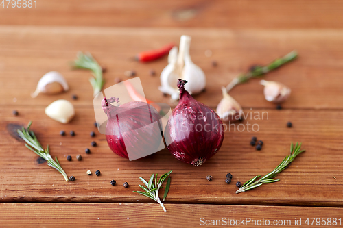 Image of onion, garlic, chili pepper and rosemary on table