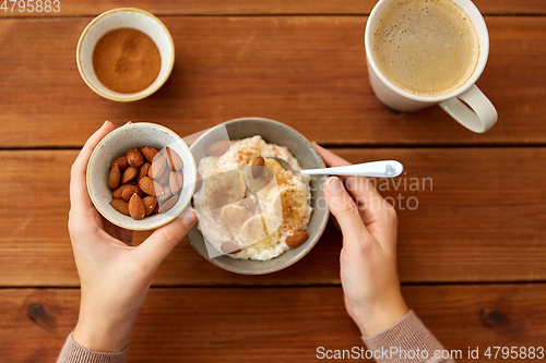 Image of hands with oatmeal breakfast and cup of coffee