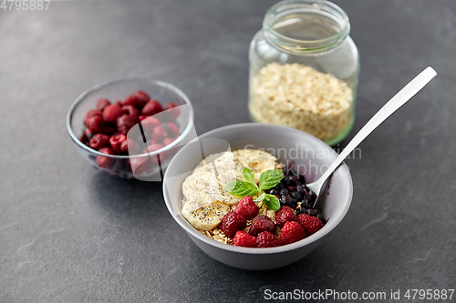 Image of cereal breakfast with berries, banana and spoon