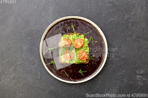 Image of toast bread with mashed avocado and cherry tomato