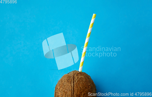 Image of coconut drink with paper straw on blue background