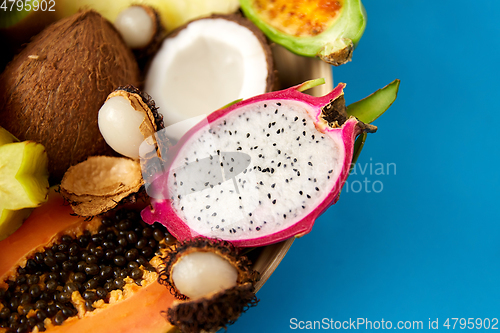 Image of plate of exotic fruits on blue background