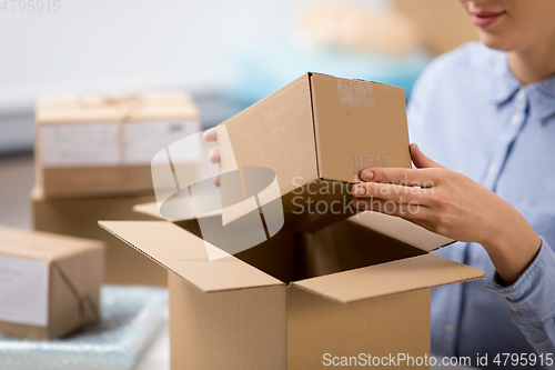 Image of woman packing parcel box at post office