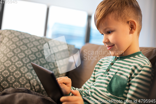 Image of happy little boy with tablet computer at home