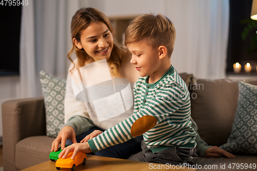 Image of mother and son playing with toy cars at home