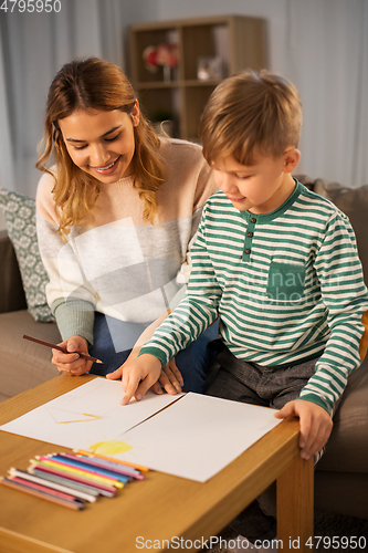 Image of mother and son with pencils drawing at home