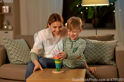 Image of mother and son playing with toy pyramid at home