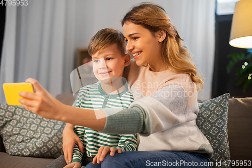 Image of mother and son taking selfie by smartphone at home