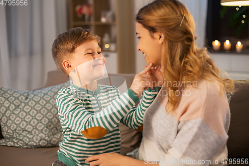 Image of happy smiling mother talking to her son at home