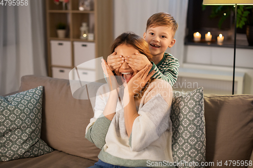 Image of happy smiling mother playing with her son at home