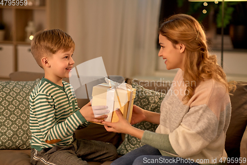 Image of little son giving present to mother at home