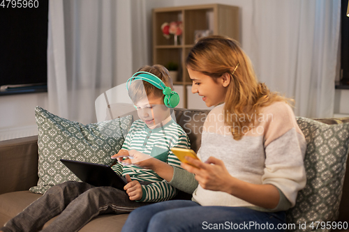 Image of mother and son using gadgets at home